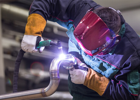 Man welding stainless-steel pipe