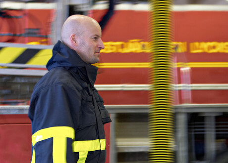 marshfield_fire_department-fire-fighter-walking-in-front-of-fire-truck-and-exhaust-extraction-hose