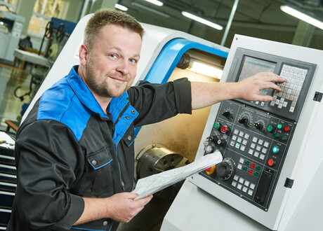 Worker sets CNC machine 